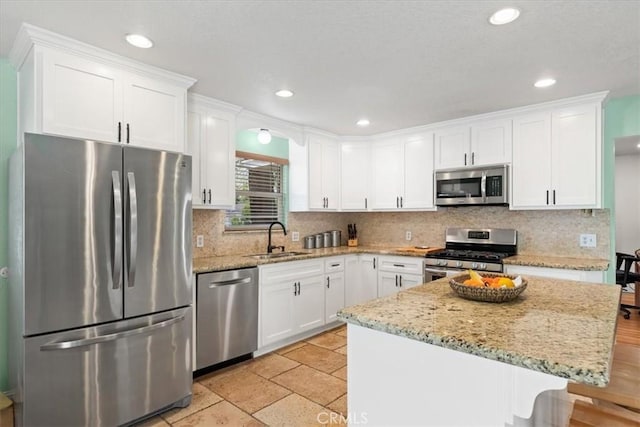kitchen with white cabinets, backsplash, appliances with stainless steel finishes, and a sink