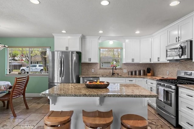 kitchen with white cabinets, plenty of natural light, and appliances with stainless steel finishes