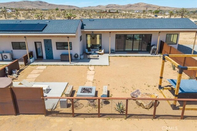 3170 Wesley Rd, Joshua Tree, CA 92252 - back of house featuring a patio, a mountain view, a shingled roof, and stucco siding