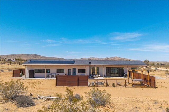 3170 Wesley Rd, Joshua Tree, CA 92252 - back of property featuring roof mounted solar panels, a mountain view, a patio area, and view of desert
