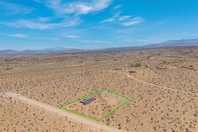 3170 Wesley Rd, Joshua Tree, CA 92252 - aerial view of sparsely populated area with a desert landscape, a mountainous background, and property parcel outlined