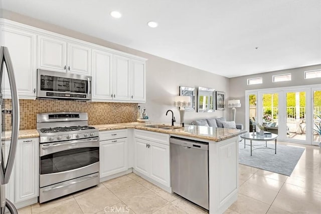 9 Gema, San Clemente, CA 92672 - kitchen with stainless steel appliances, a sink, open floor plan, a peninsula, and tasteful backsplash