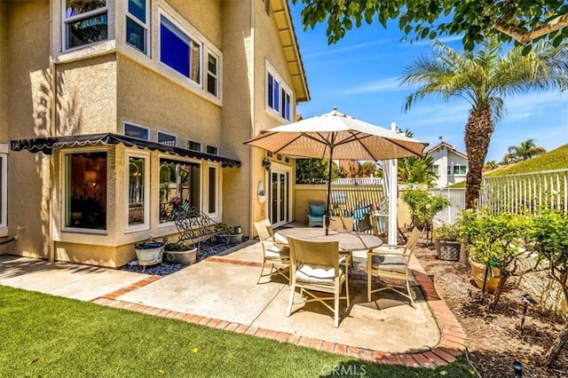 view of patio featuring outdoor dining space and fence