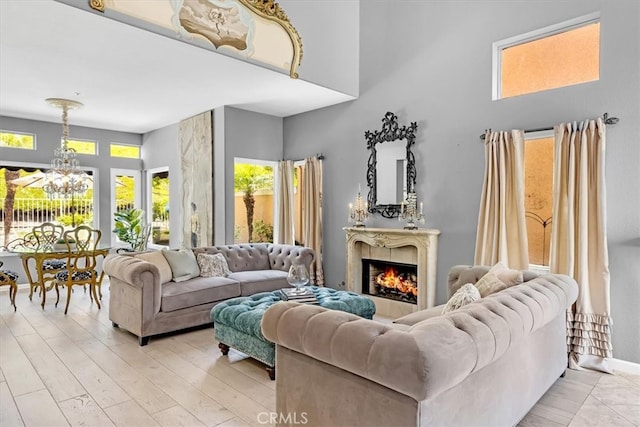 9 Gema, San Clemente, CA 92672 - living area with a high ceiling, a chandelier, healthy amount of natural light, a lit fireplace, and light wood-style flooring