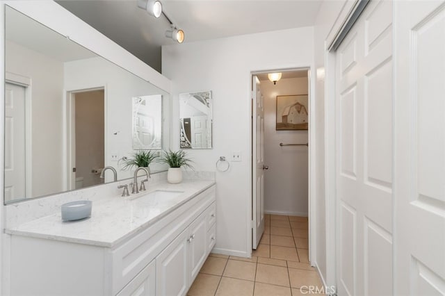 bathroom with baseboards, vanity, and tile patterned flooring
