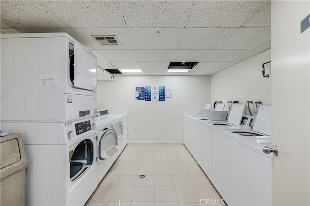 7211 Cozycroft Ave Unit 19, Winnetka, CA 91306 - communal laundry room with stacked washing machine and dryer, washing machine and dryer, light tile patterned floors, and baseboards