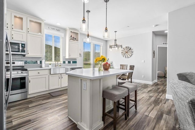 2815 Miller Valley Rd, Pine Valley, CA 91962 - kitchen with stainless steel appliances, a breakfast bar, dark wood-style floors, backsplash, and a kitchen island