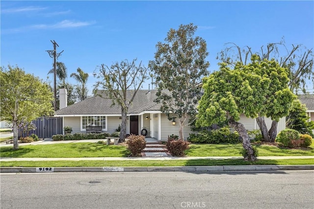 view of front of property featuring fence and a front lawn