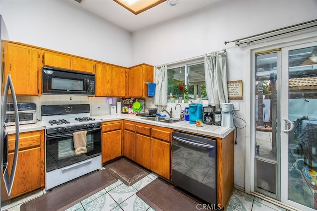 916 Award Dr, Colton, CA 92324 - kitchen featuring black appliances, a sink, decorative backsplash, brown cabinetry, and tile counters