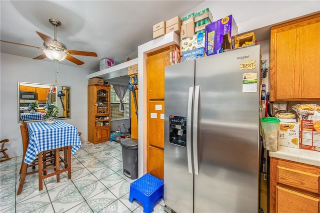 916 Award Dr, Colton, CA 92324 - kitchen featuring stainless steel fridge with ice dispenser, tile counters, black microwave, ceiling fan, and brown cabinets