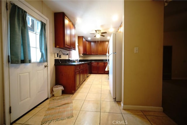 73203 Sun Valley Dr Unit 29, Palms, CA 92277 - kitchen with freestanding refrigerator, dark countertops, light tile patterned floors, and ceiling fan