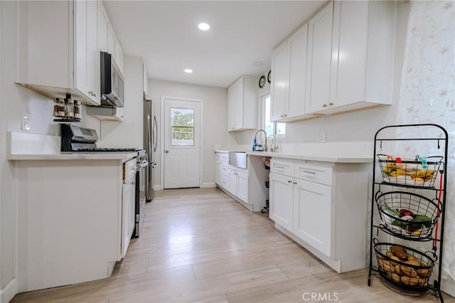 1924 Hunter Rd, Colton, CA 92324 - kitchen featuring appliances with stainless steel finishes, light wood-style floors, light countertops, white cabinets, and recessed lighting