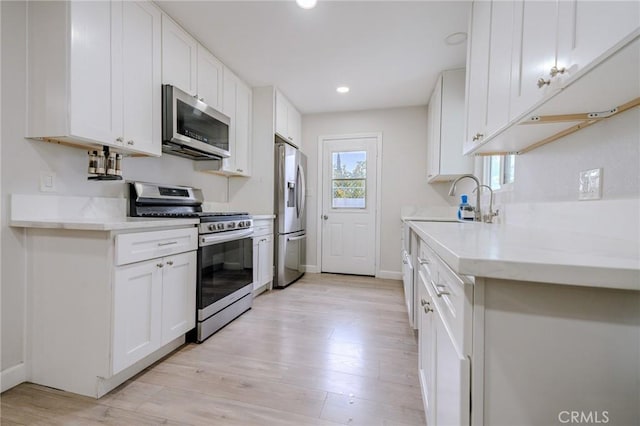 1924 Hunter Rd, Colton, CA 92324 - kitchen with stainless steel appliances, light wood-type flooring, white cabinetry, and recessed lighting