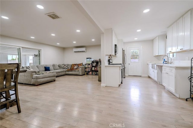 1924 Hunter Rd, Colton, CA 92324 - living area with a wall unit AC, light wood-style flooring, and recessed lighting