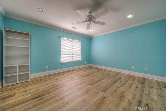 spare room featuring baseboards, visible vents, and ornamental molding