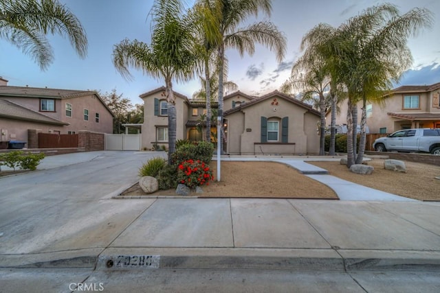 mediterranean / spanish-style home with fence and stucco siding