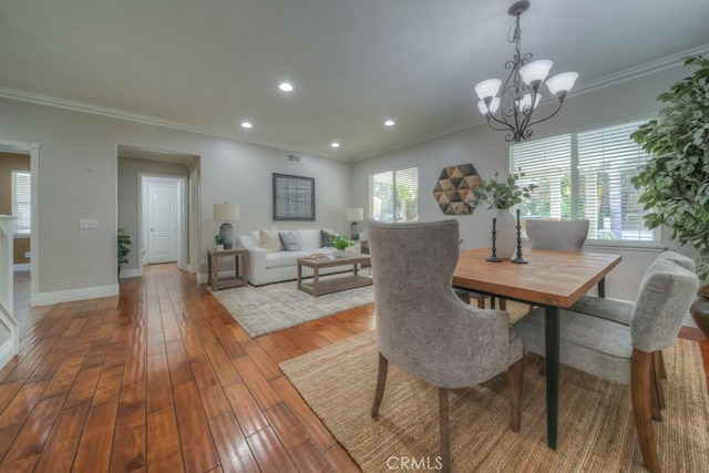 dining room featuring crown molding, wood-type flooring, baseboards, recessed lighting, and a notable chandelier