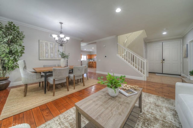 living room featuring stairway, ornamental molding, hardwood / wood-style flooring, and a notable chandelier