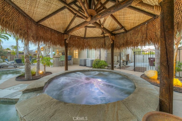 exterior space with a hot tub, a wealth of natural light, and high vaulted ceiling