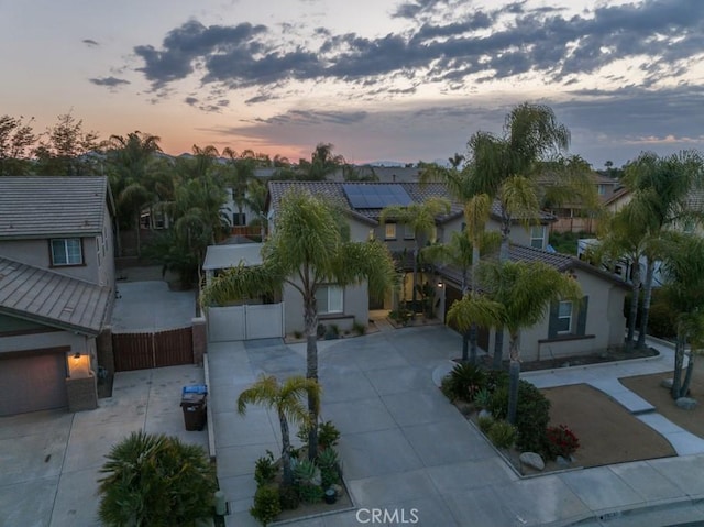 view of front of house featuring a residential view, fence, stucco siding, a gate, and driveway