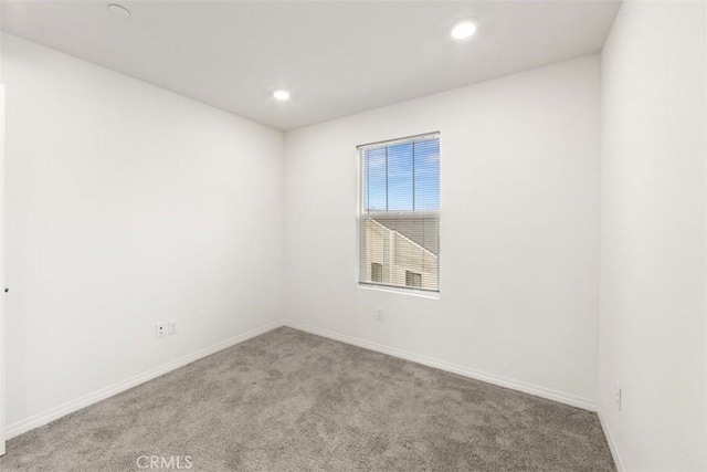 unfurnished room with baseboards, recessed lighting, and carpet