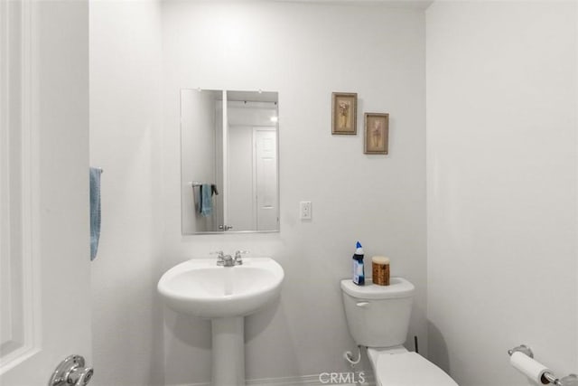 half bathroom with toilet and a sink