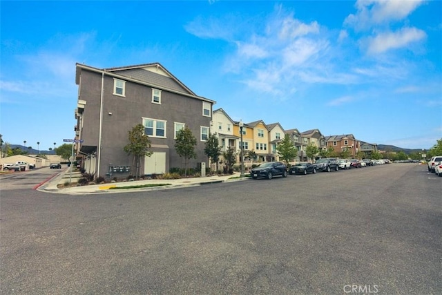 view of road with a residential view, sidewalks, and curbs