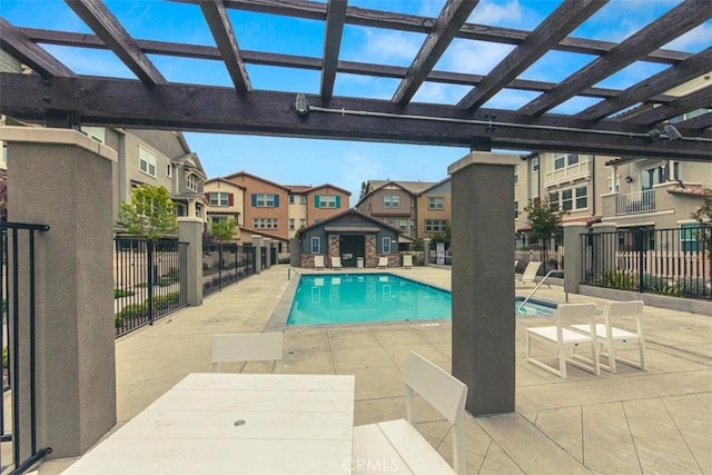 community pool with fence, a pergola, a patio area, and a residential view