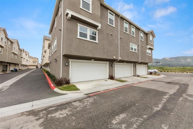 exterior space with an attached garage, driveway, and a residential view