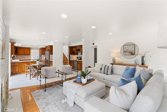 living room featuring stairway, visible vents, recessed lighting, and light wood-style flooring
