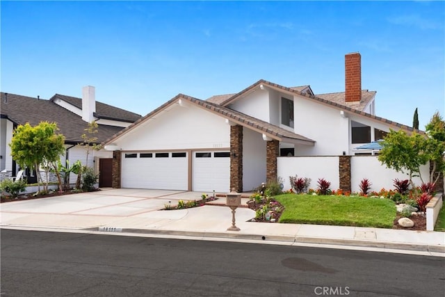 view of front of house featuring stucco siding, driveway, a chimney, an attached garage, and fence
