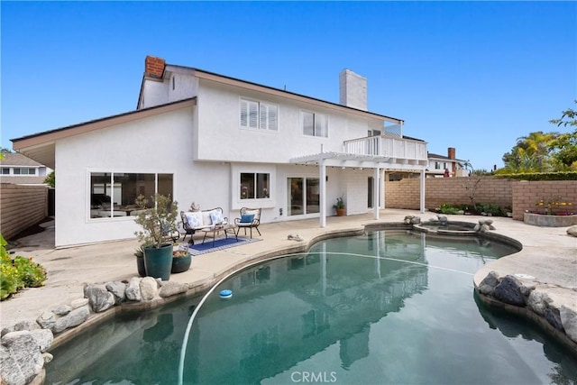 back of house featuring a chimney, a fenced backyard, stucco siding, a patio area, and a pergola