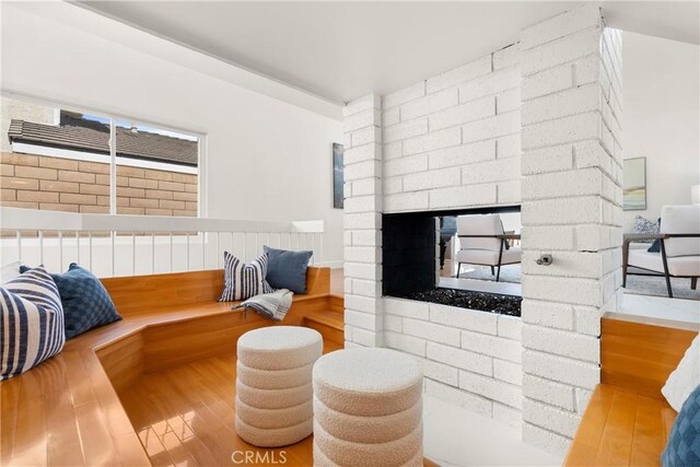 sitting room with wood finished floors and a brick fireplace