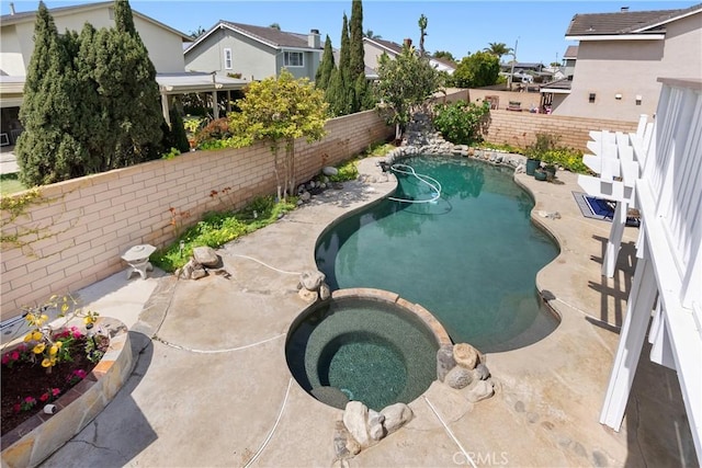 view of swimming pool with a fenced backyard, a residential view, a pool with connected hot tub, and a patio area