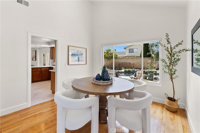 dining room with visible vents, light wood-style floors, and baseboards