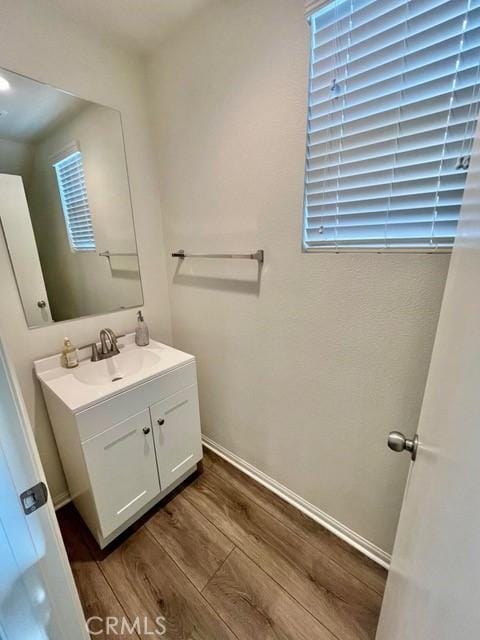 2819 La Calle Sabio Ave, Rosamond, CA 93560 - bathroom featuring wood finished floors, vanity, and baseboards