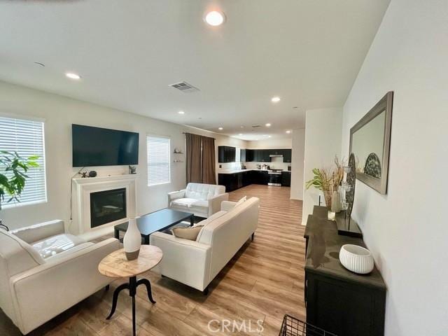 2819 La Calle Sabio Ave, Rosamond, CA 93560 - living room with light wood-style flooring, recessed lighting, and a glass covered fireplace