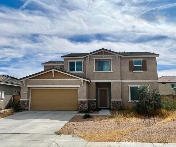2819 La Calle Sabio Ave, Rosamond, CA 93560 - view of front of house with stone siding, stucco siding, concrete driveway, and a garage