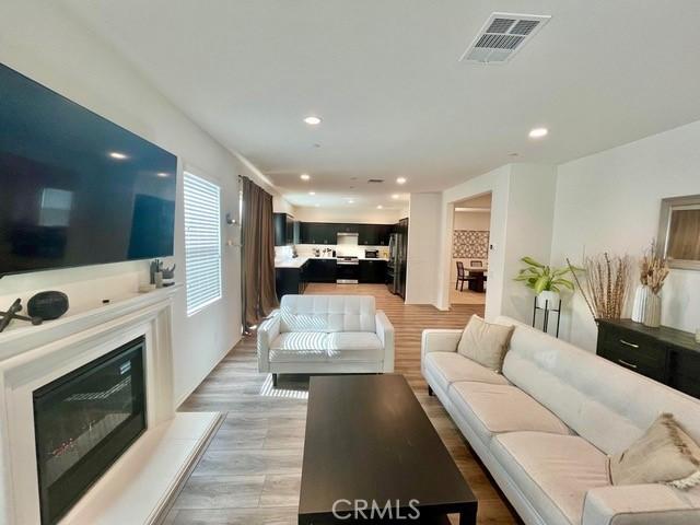 2819 La Calle Sabio Ave, Rosamond, CA 93560 - living room featuring recessed lighting, light wood-style floors, and a glass covered fireplace