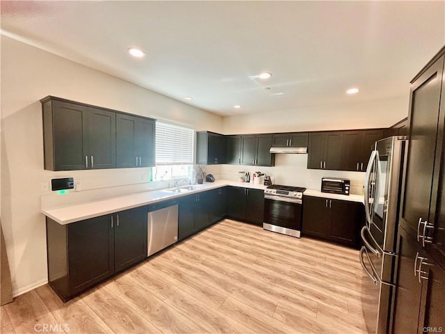 2819 La Calle Sabio Ave, Rosamond, CA 93560 - kitchen with appliances with stainless steel finishes, a sink, light countertops, light wood finished floors, and recessed lighting