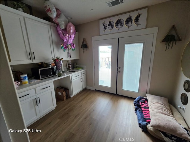 24236 Cahuilla Rd, Apple Valley, CA 92307 - kitchen with stainless steel microwave, french doors, light countertops, and plenty of natural light