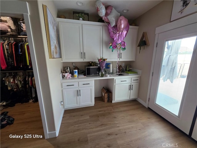24236 Cahuilla Rd, Apple Valley, CA 92307 - bar area with stainless steel microwave, light wood-type flooring, and baseboards