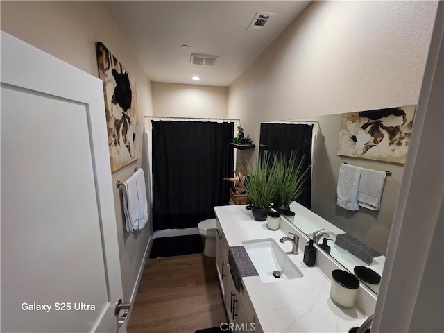 24236 Cahuilla Rd, Apple Valley, CA 92307 - bathroom featuring vanity, toilet, curtained shower, and wood finished floors