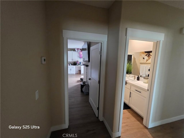 24236 Cahuilla Rd, Apple Valley, CA 92307 - hallway featuring wood finished floors, baseboards, and a sink
