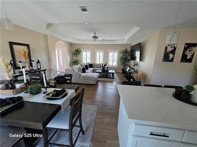 24236 Cahuilla Rd, Apple Valley, CA 92307 - dining area with a raised ceiling, arched walkways, ceiling fan, and dark wood finished floors