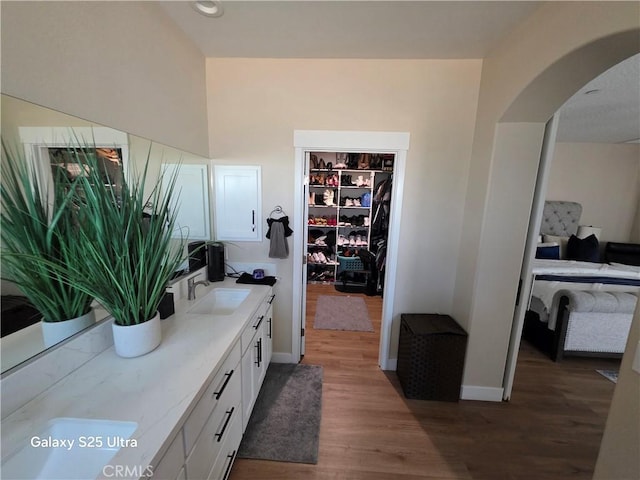 24236 Cahuilla Rd, Apple Valley, CA 92307 - bathroom featuring wood finished floors, double vanity, ensuite bath, baseboards, and a walk in closet