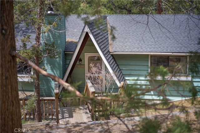 exterior space with roof with shingles