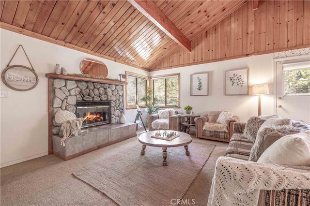 carpeted living area featuring vaulted ceiling with beams, a stone fireplace, and wooden ceiling