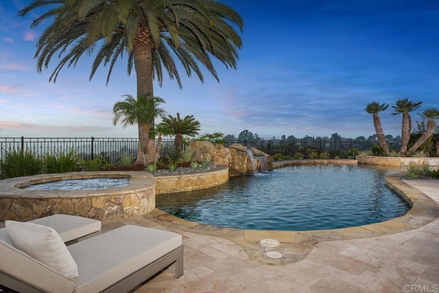 5015 Rancho Quinta Bnd, San Diego, CA 92130 - pool at dusk featuring a fenced backyard, a pool with connected hot tub, and a patio area