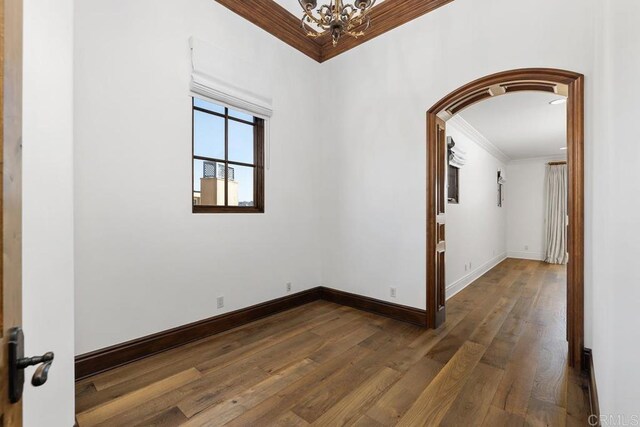 5015 Rancho Quinta Bnd, San Diego, CA 92130 - empty room featuring ornamental molding, a chandelier, arched walkways, and dark wood-style flooring